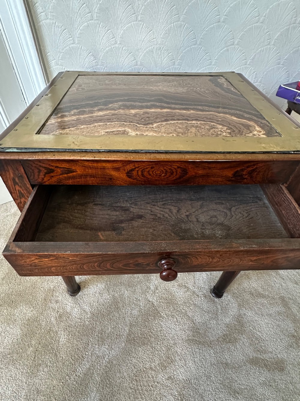 A dark brown Victorian wooden side table with turned legs, a single drawer, and an inset brown marble top with a brass frame. View V