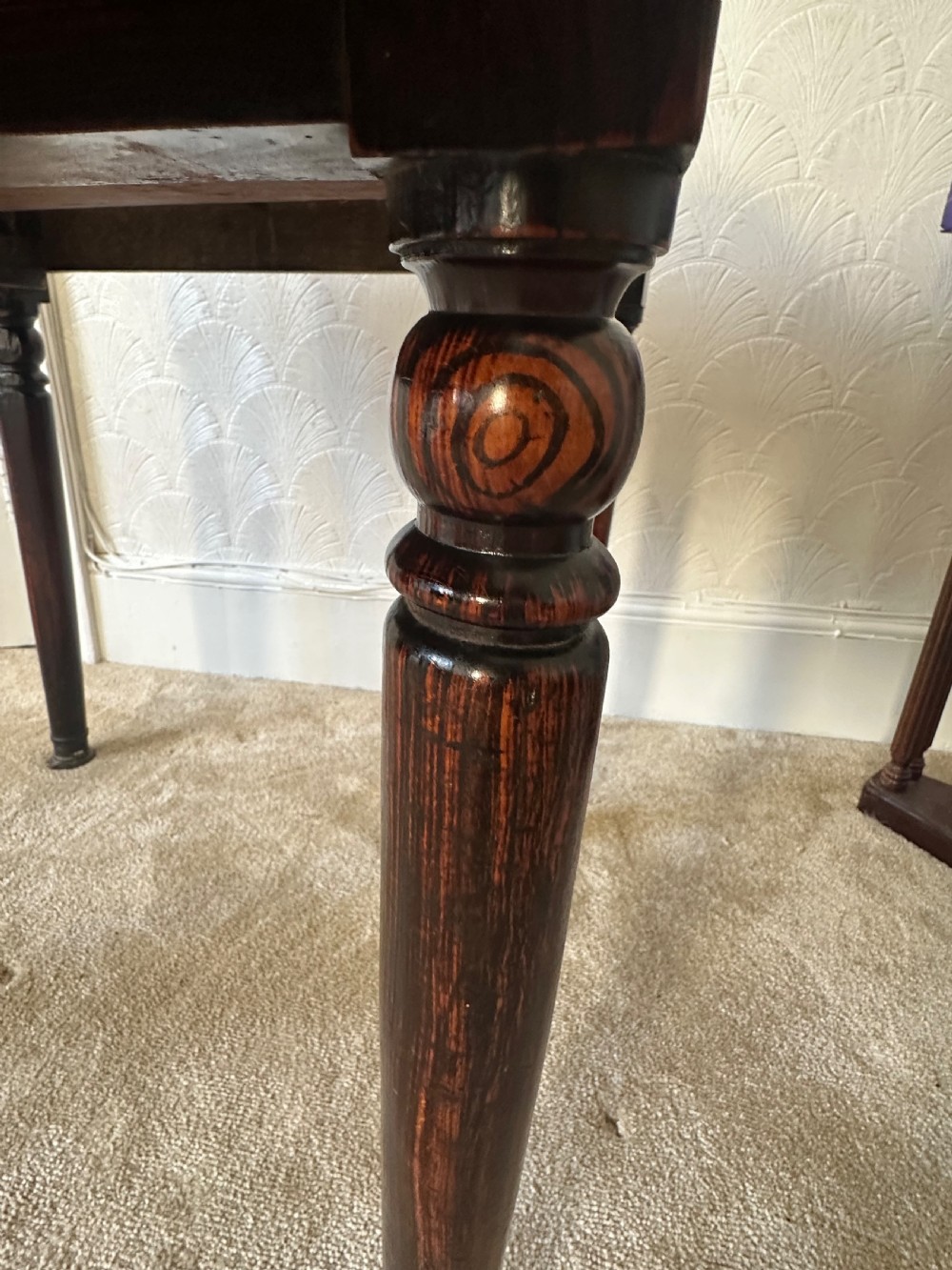 A dark brown Victorian wooden side table with turned legs, a single drawer, and an inset brown marble top with a brass frame. View VIII