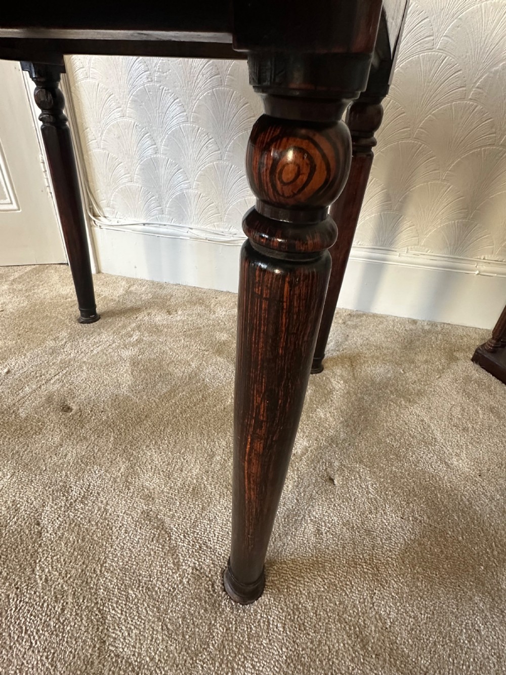 A dark brown Victorian wooden side table with turned legs, a single drawer, and an inset brown marble top with a brass frame. View IX