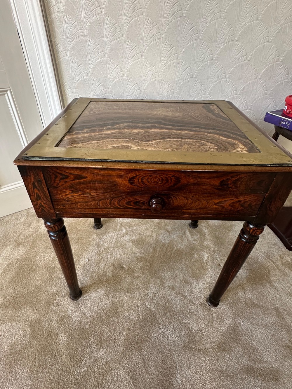 A dark brown Victorian wooden side table with turned legs, a single drawer, and an inset brown marble top with a brass frame. View XI