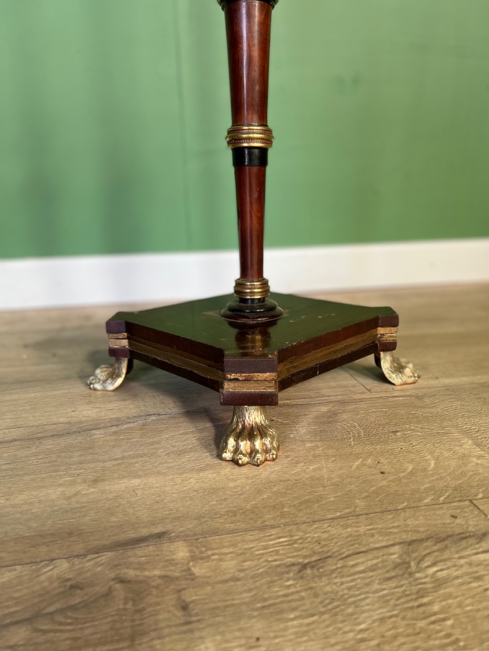 An antique Regency pole fire screen featuring an octagonal pokerwork panel supported on a turned wooden column with a plinth base resting on brass claw feet. View III