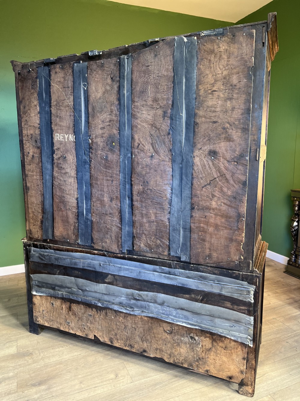 A mid-18th-century dark oak tack cupboard featuring arched panelled upper doors and a lower drawer section with brass handles. View VII
