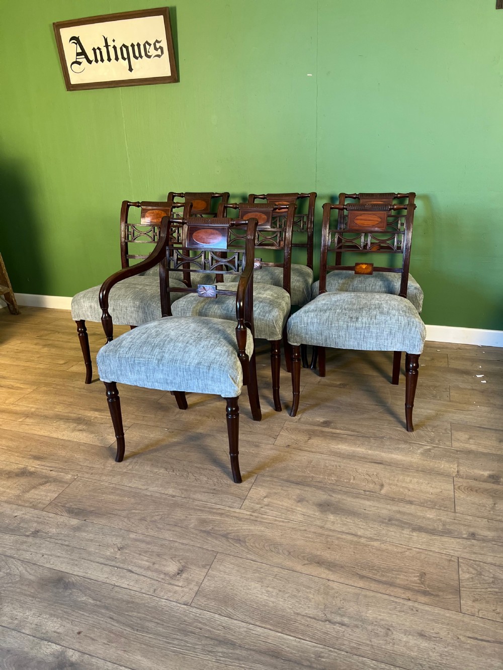 A set of seven Regency mahogany dining chairs with inlaid geometric backs and pale blue upholstered seats, featuring one carver armchair. View II