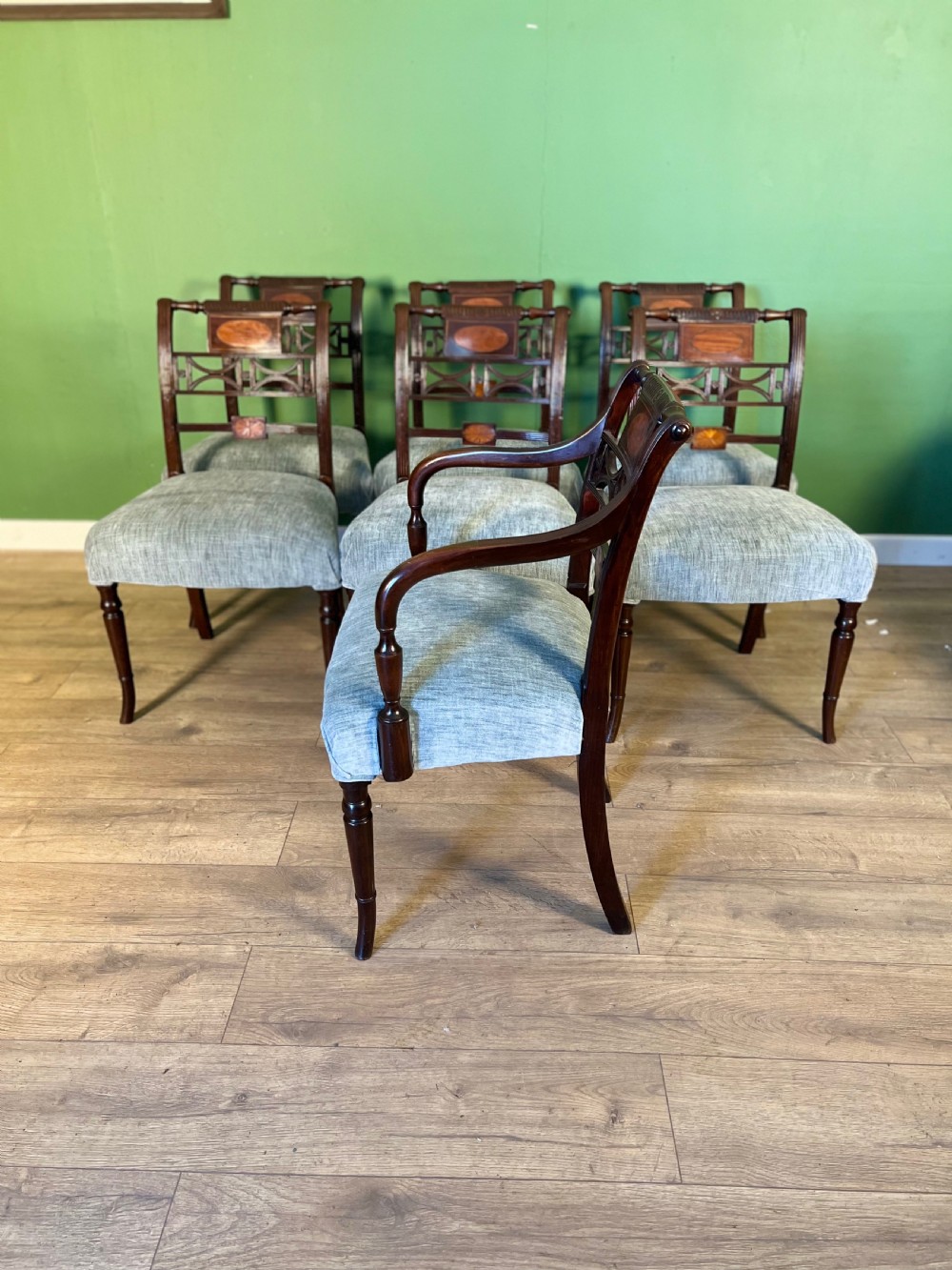 A set of seven Regency mahogany dining chairs with inlaid geometric backs and pale blue upholstered seats, featuring one carver armchair. View III