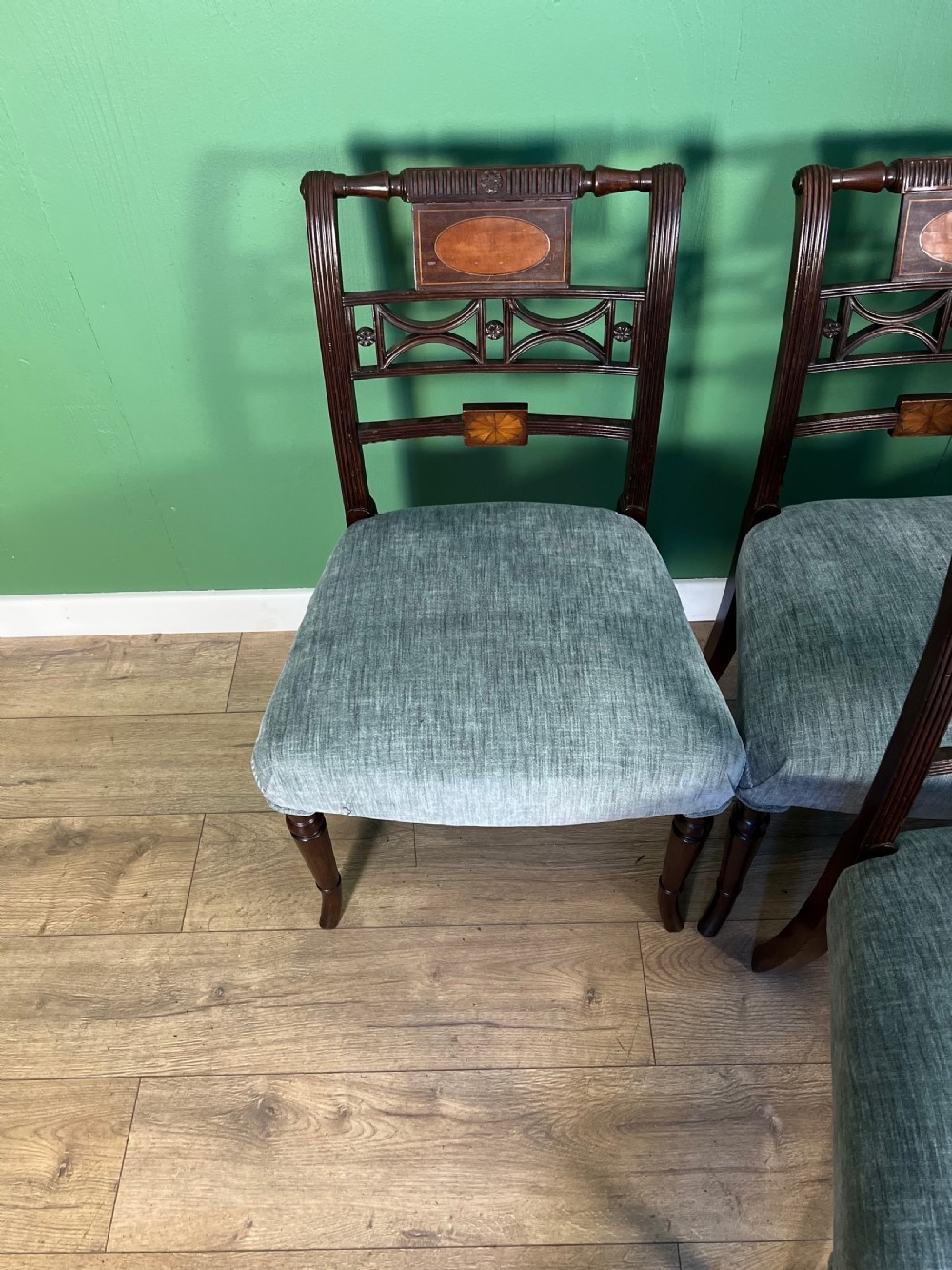 A set of seven Regency mahogany dining chairs with inlaid geometric backs and pale blue upholstered seats, featuring one carver armchair. View IV