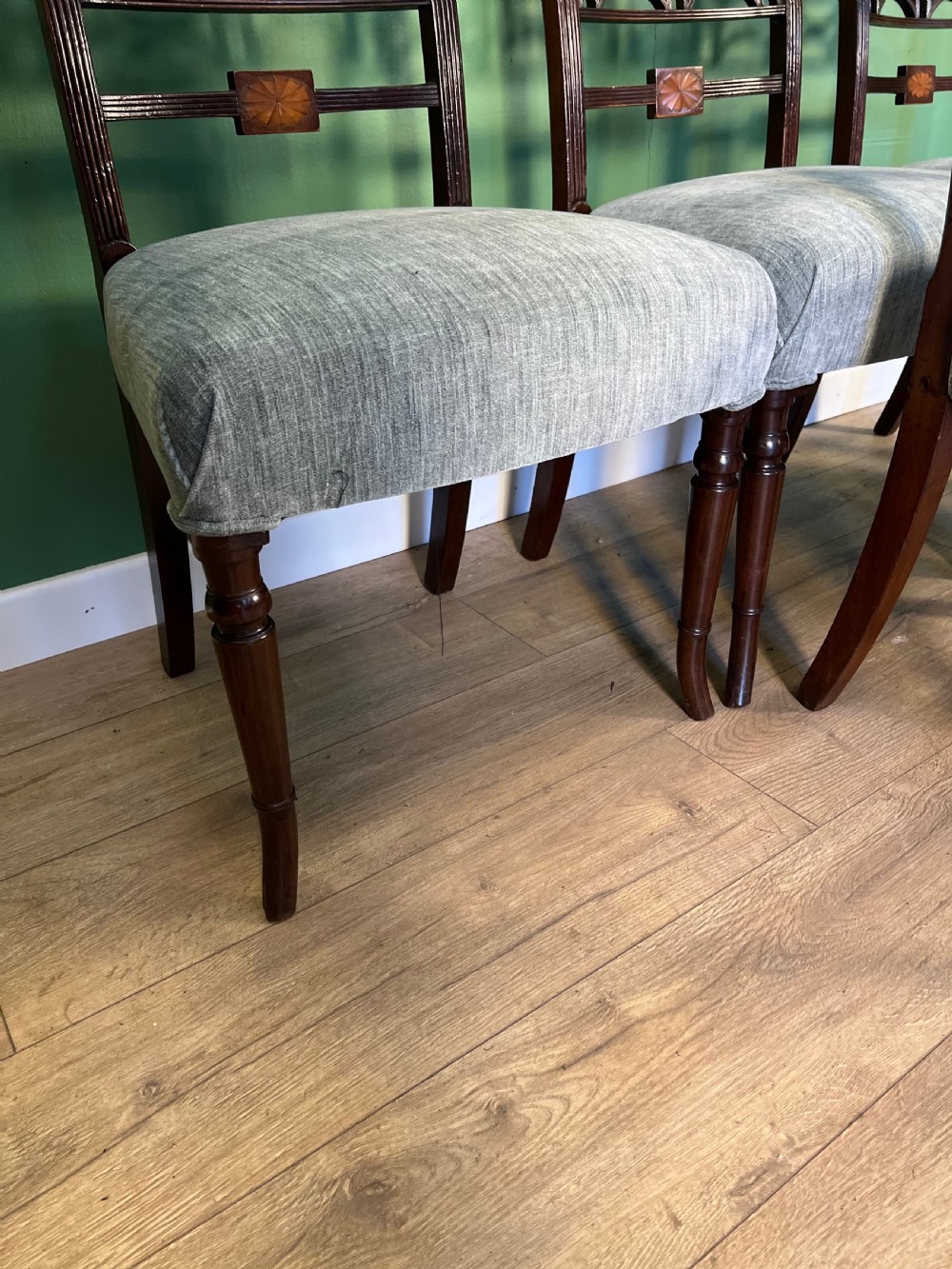 A set of seven Regency mahogany dining chairs with inlaid geometric backs and pale blue upholstered seats, featuring one carver armchair. View V