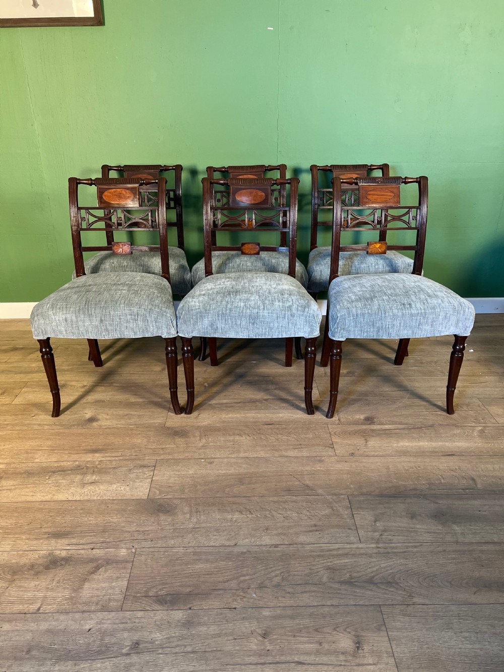 A set of seven Regency mahogany dining chairs with inlaid geometric backs and pale blue upholstered seats, featuring one carver armchair. View VI