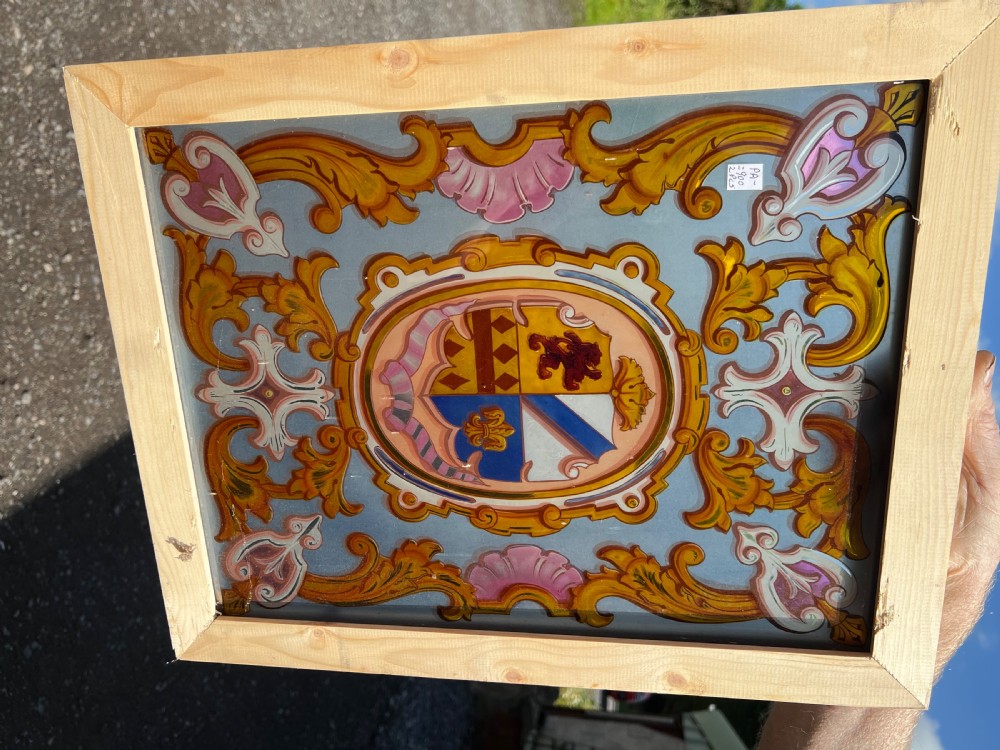 Rectangular painted glass panel featuring a central coat of arms inside an oval cartouche with scrolling acanthus leaf ornament, framed in light pine wood. View IV