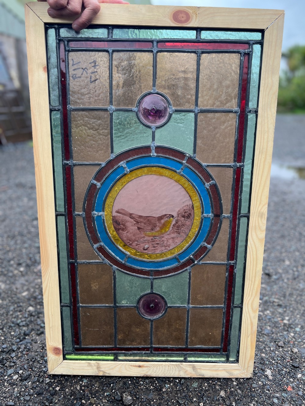 A rectangular Victorian leaded glass window panel featuring a central hand-painted bird roundel framed by colourful geometric borders and circular bullseye glass accents. View III