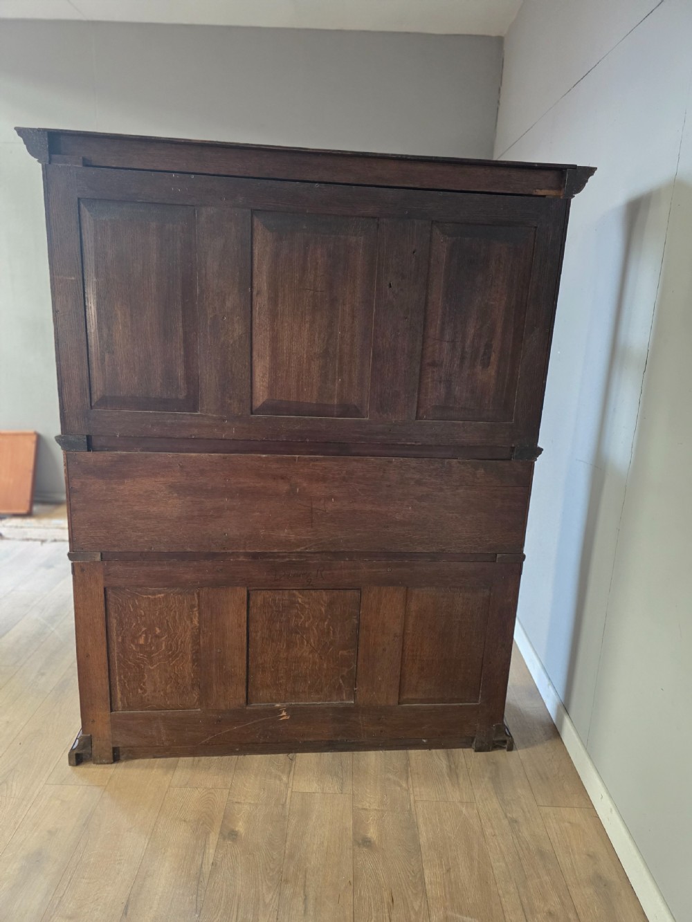 A late 19th-century carved oak cabinet desk with a red-lined glazed upper section, foliate carved lower panels, and brass strap hinges. View XIV