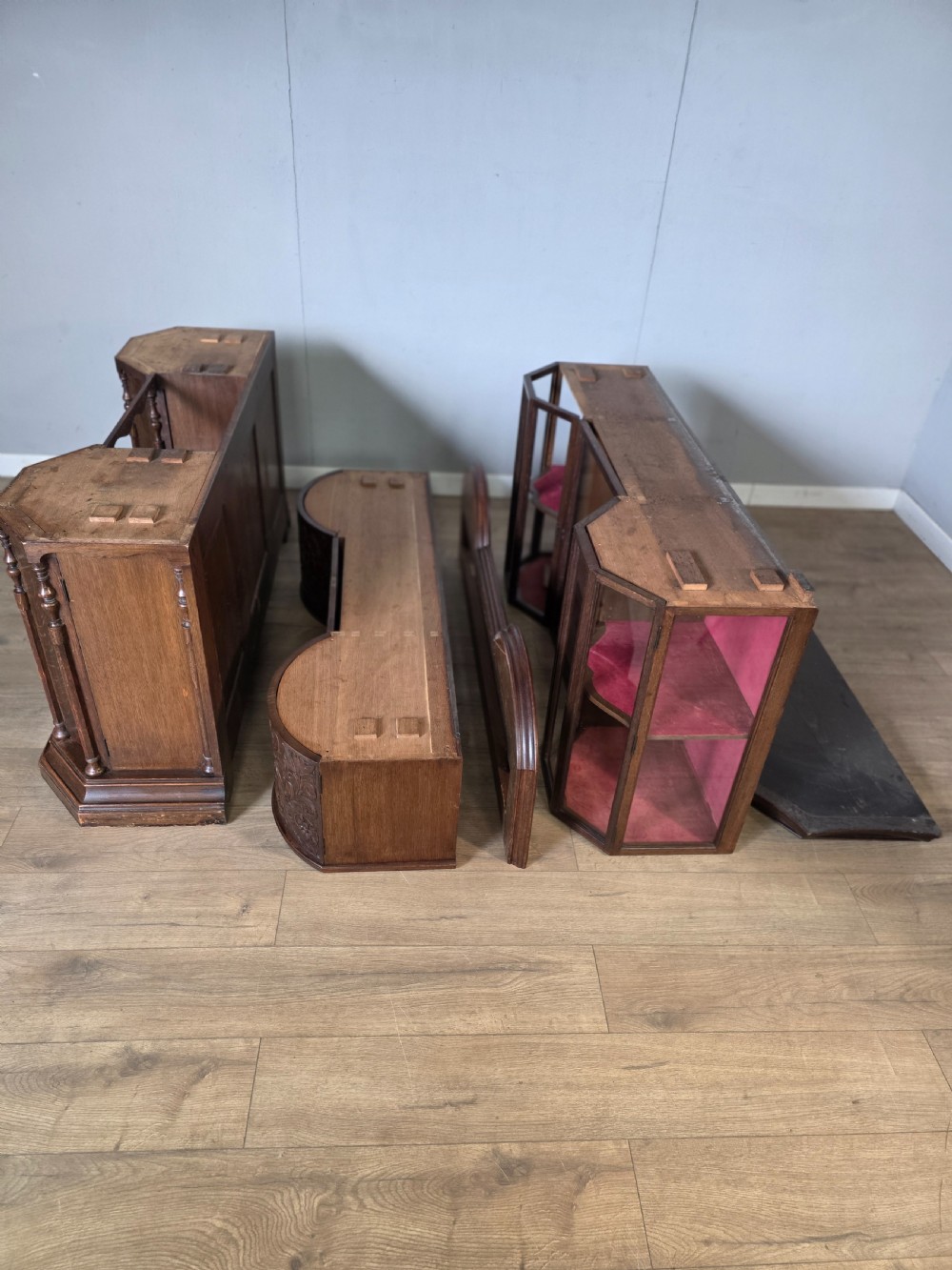 A late 19th-century carved oak cabinet desk with a red-lined glazed upper section, foliate carved lower panels, and brass strap hinges. View XV