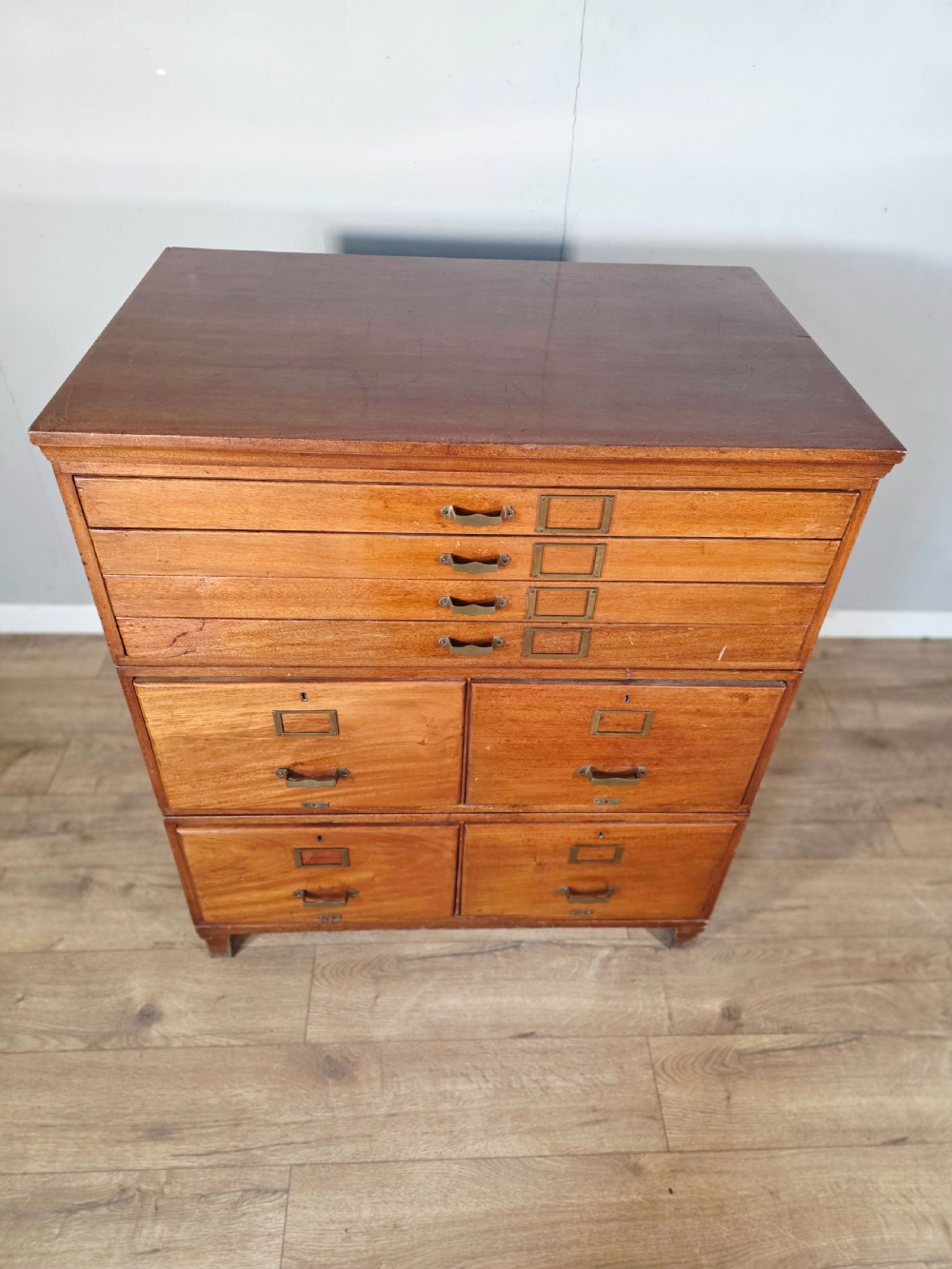 A vintage wooden sectional plan chest with multiple shallow and deep drawers fitted with brass pulls. View V