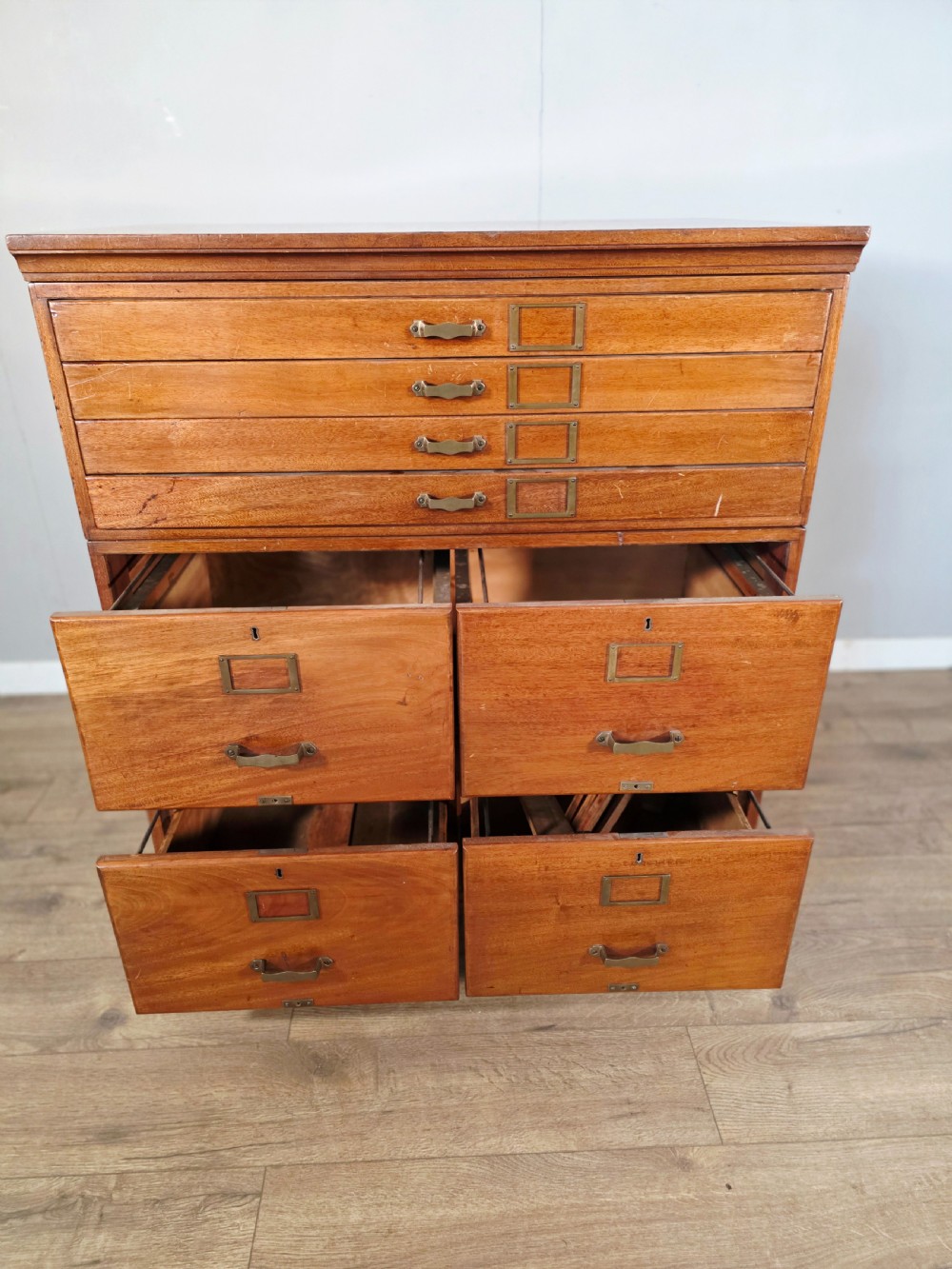 A vintage wooden sectional plan chest with multiple shallow and deep drawers fitted with brass pulls. View VIII