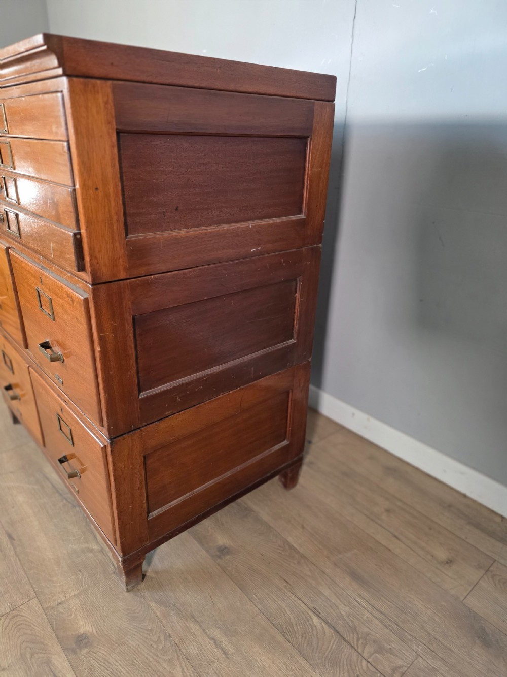 A vintage wooden sectional plan chest with multiple shallow and deep drawers fitted with brass pulls. View X