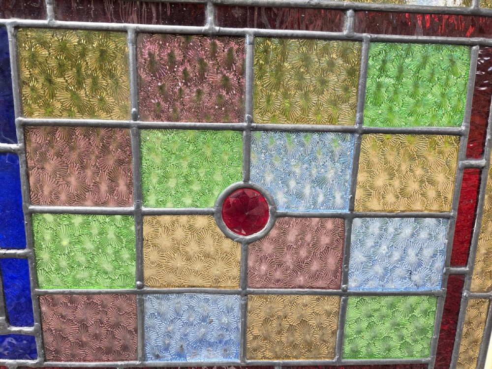 A rectangular antique leaded glass panel featuring a hand-painted central scene of a bird in flight over water lilies, surrounded by geometric colourful glass panes. View V