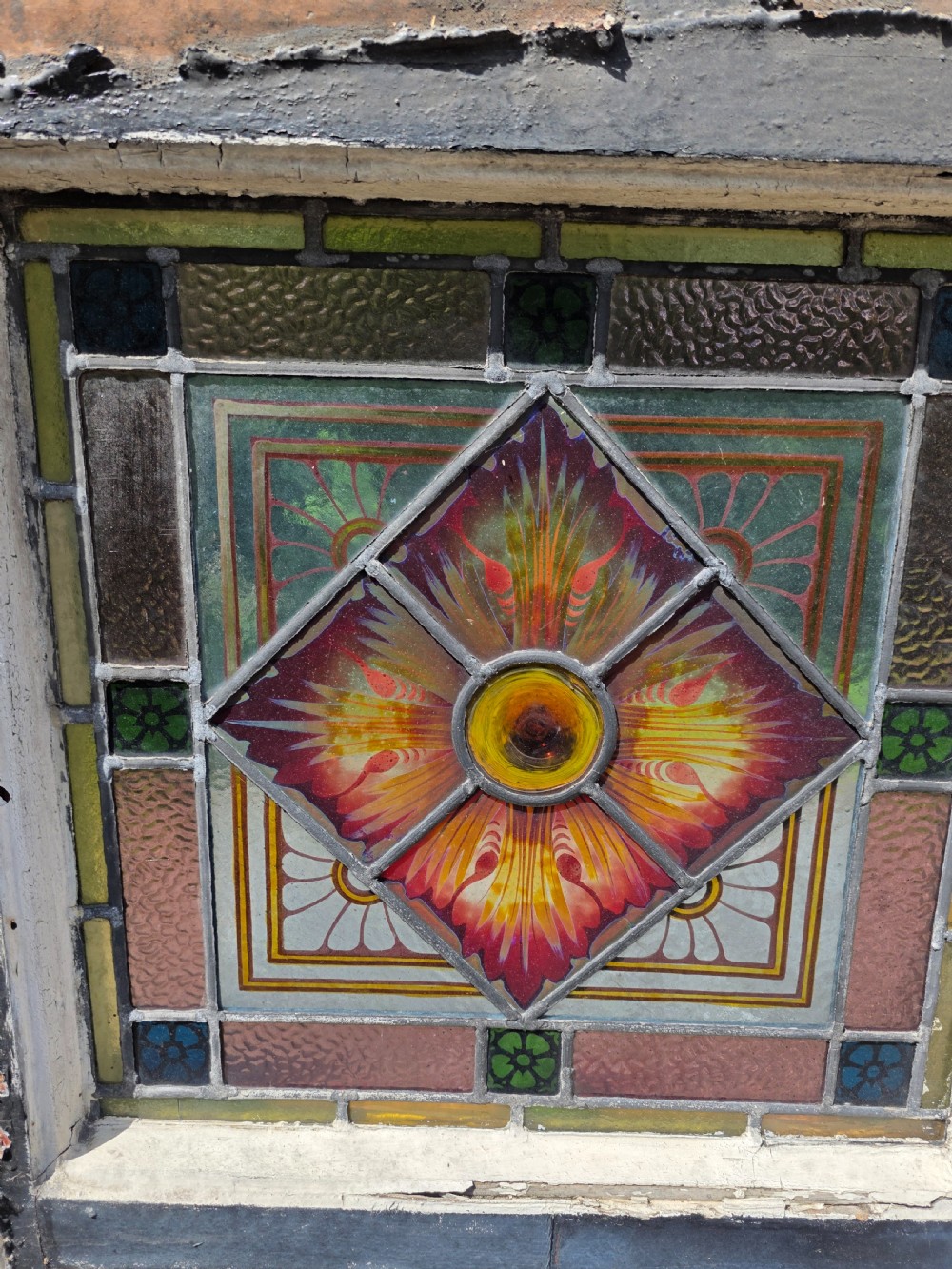 1880 antique leaded glass window with amber and green bullseyes and birds on flowers design  View IV