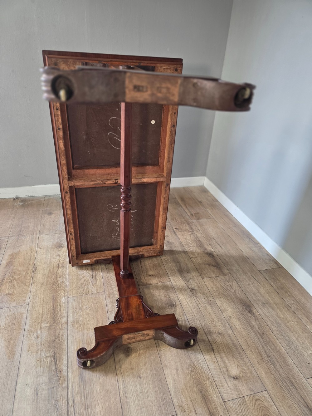 An early Victorian mahogany side table featuring a rectangular top, a central turned stretcher, and carved trestle feet resting on a light wood floor. View XIV