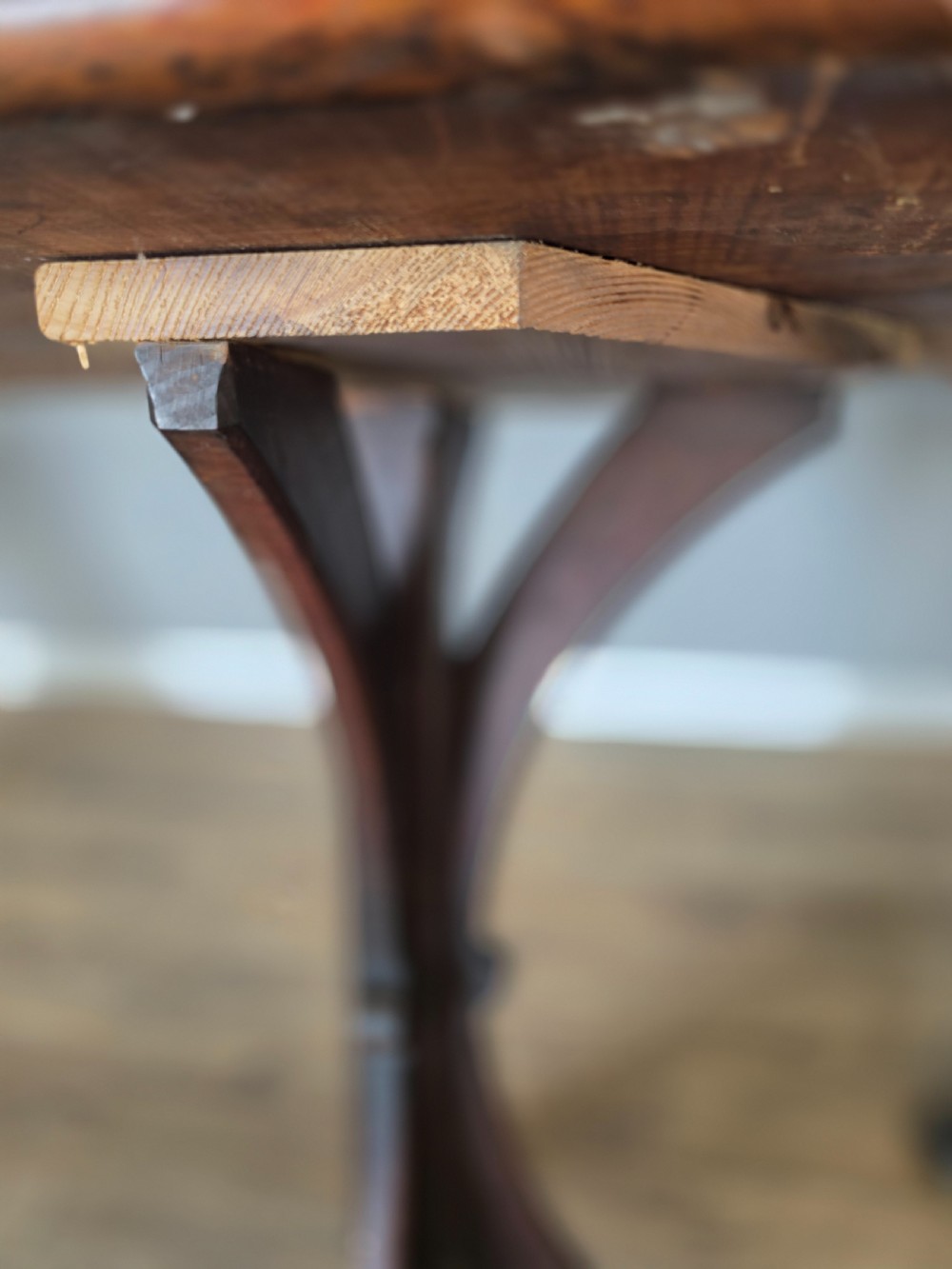 A long Victorian pitch pine centre serving table featuring a smooth rectangular top supported by curved trestle legs and a central stretcher base. View XII
