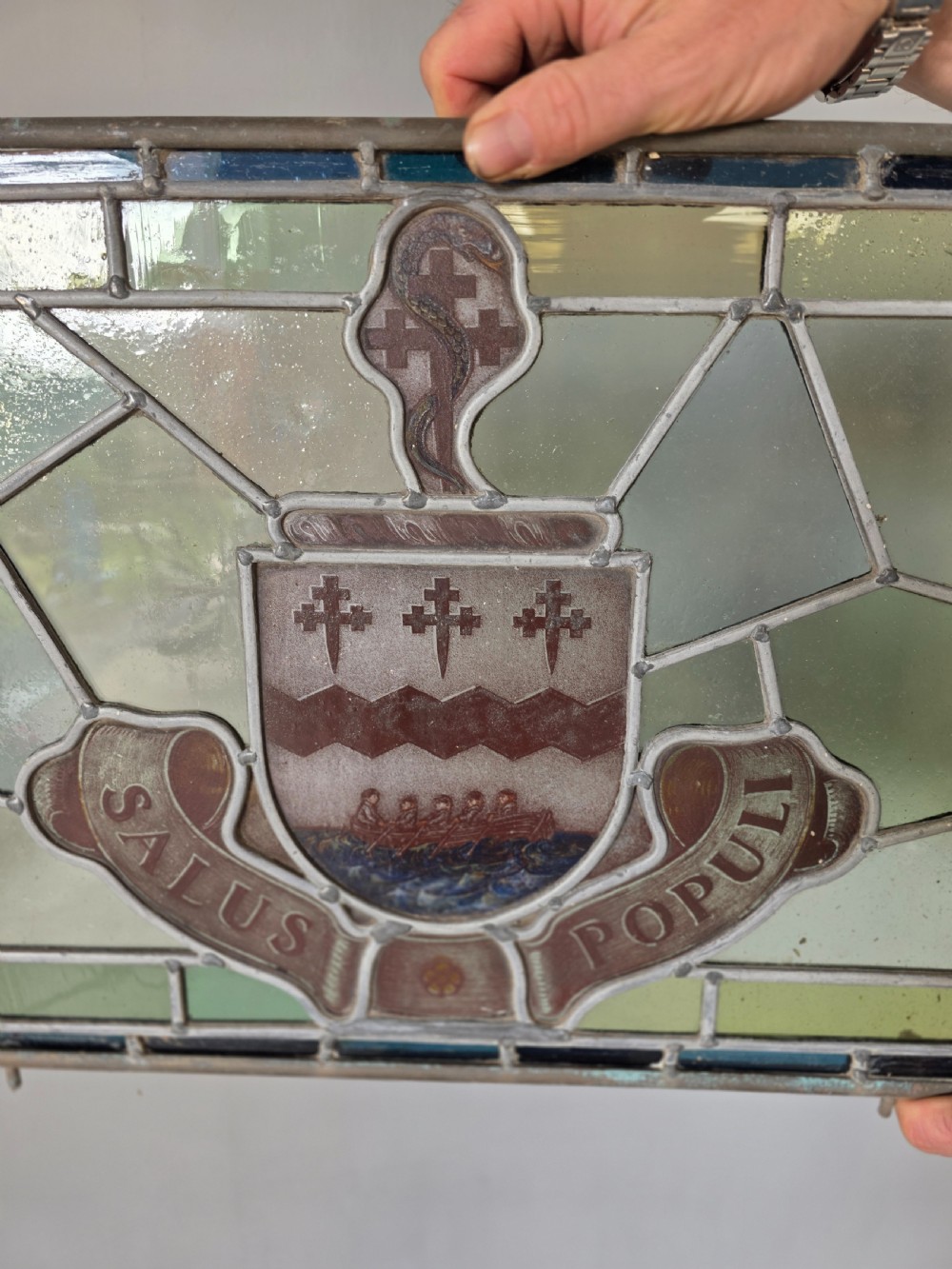 A rectangular Victorian leaded glass window panel featuring a central hand-painted heraldic coat of arms with the Latin motto Salus Populi. View II