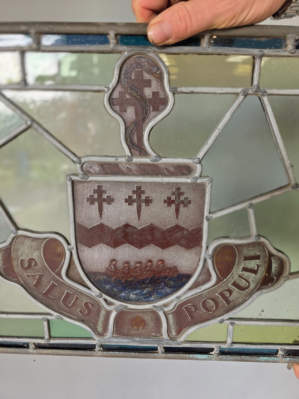 A rectangular Victorian leaded glass window panel featuring a central hand-painted heraldic coat of arms with the Latin motto Salus Populi. View III