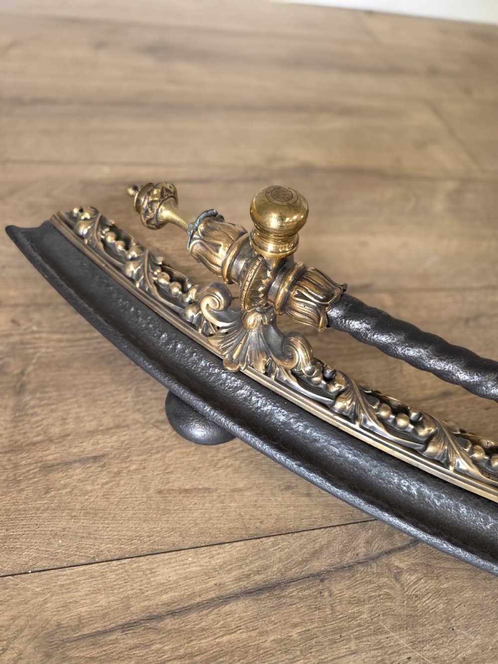 A 19th-century curved fire fender with a twisted black iron top rail and cast bronze foliate decoration. View VIII