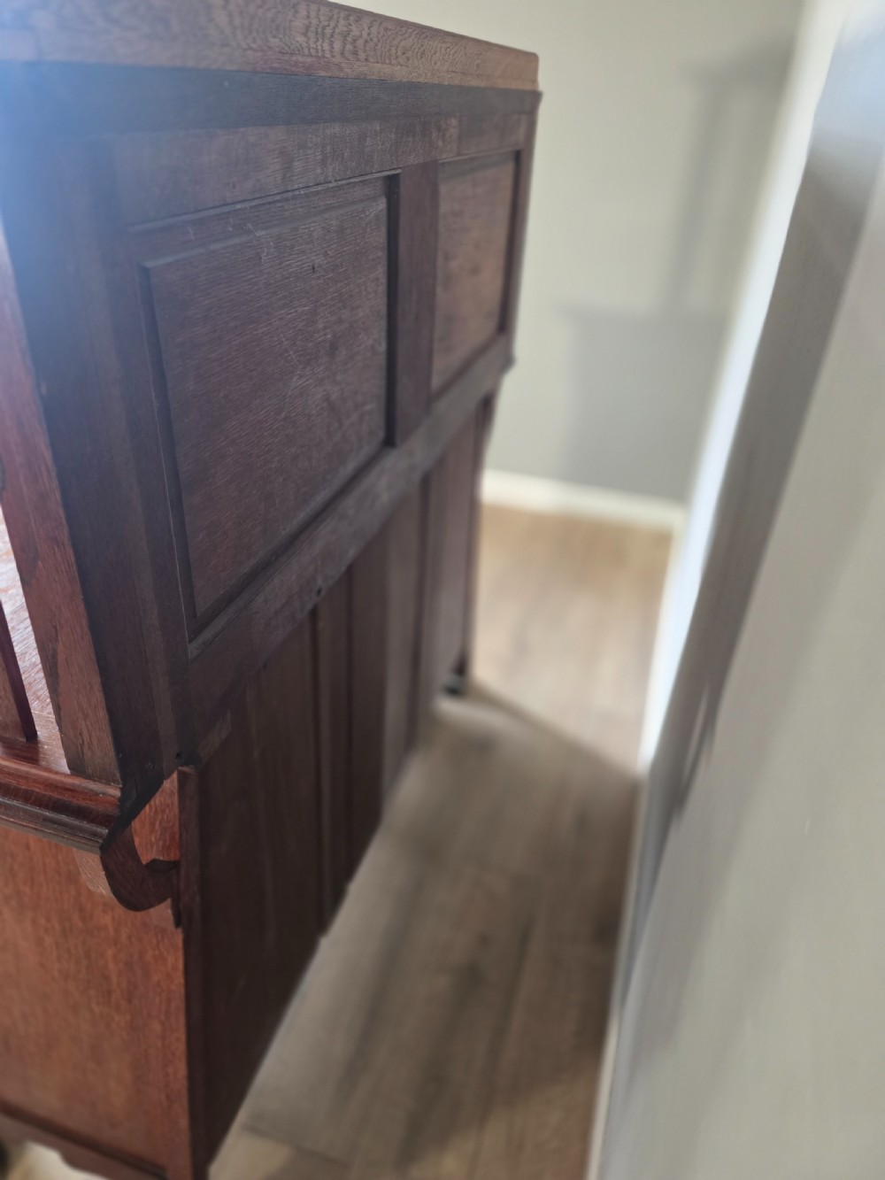 An Arts and Crafts quarter-sawn oak sideboard featuring hand-carved floral panels, copper strap hinges, central drawers, and a raised open shelf superstructure. View XX