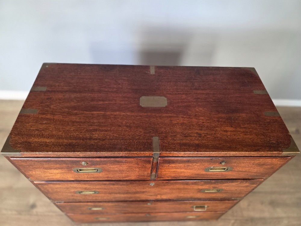 An 1830s Regency teak military campaign chest of drawers with flush brass corner brackets, strapwork, keyholes, and inset handles. View XI