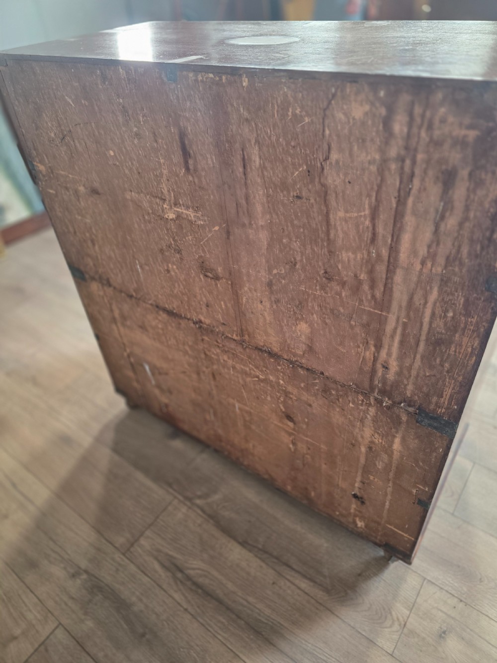 An 1830s Regency teak military campaign chest of drawers with flush brass corner brackets, strapwork, keyholes, and inset handles. View XIV