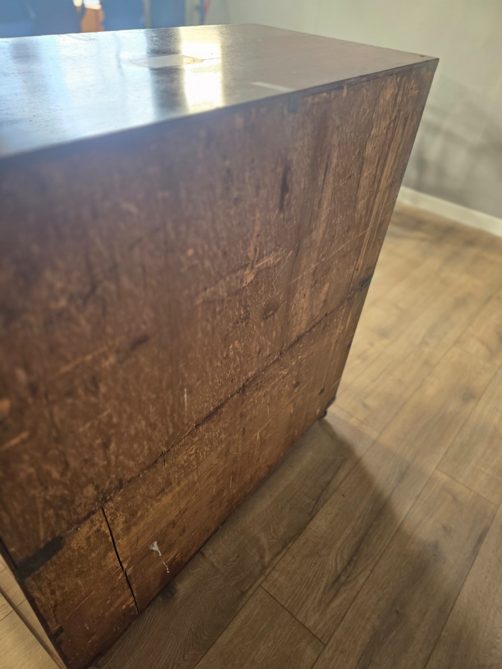 An 1830s Regency teak military campaign chest of drawers with flush brass corner brackets, strapwork, keyholes, and inset handles. View XV