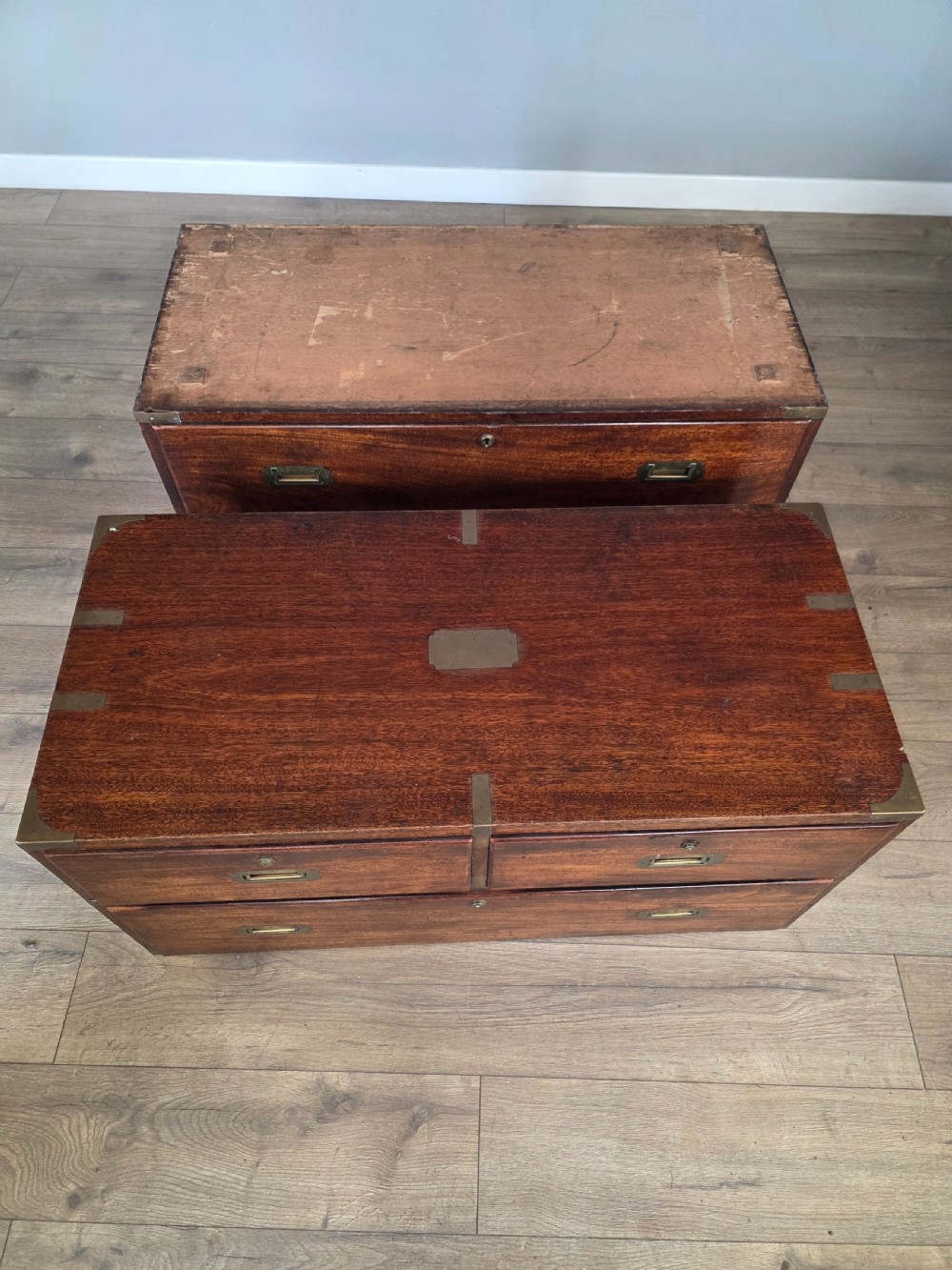 An 1830s Regency teak military campaign chest of drawers with flush brass corner brackets, strapwork, keyholes, and inset handles. View XX