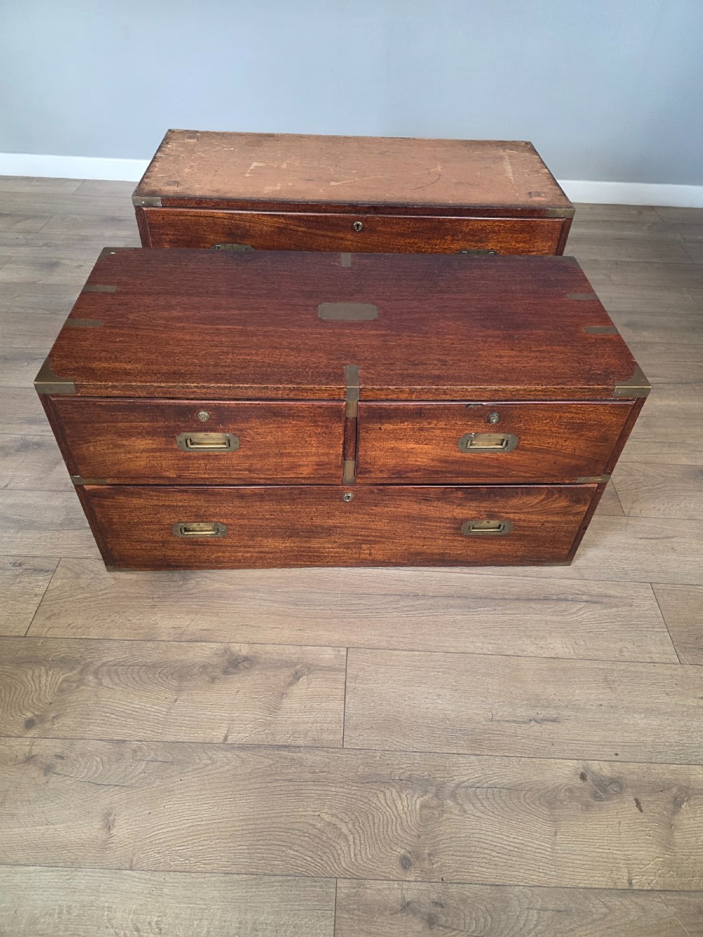 An 1830s Regency teak military campaign chest of drawers with flush brass corner brackets, strapwork, keyholes, and inset handles. View XXI
