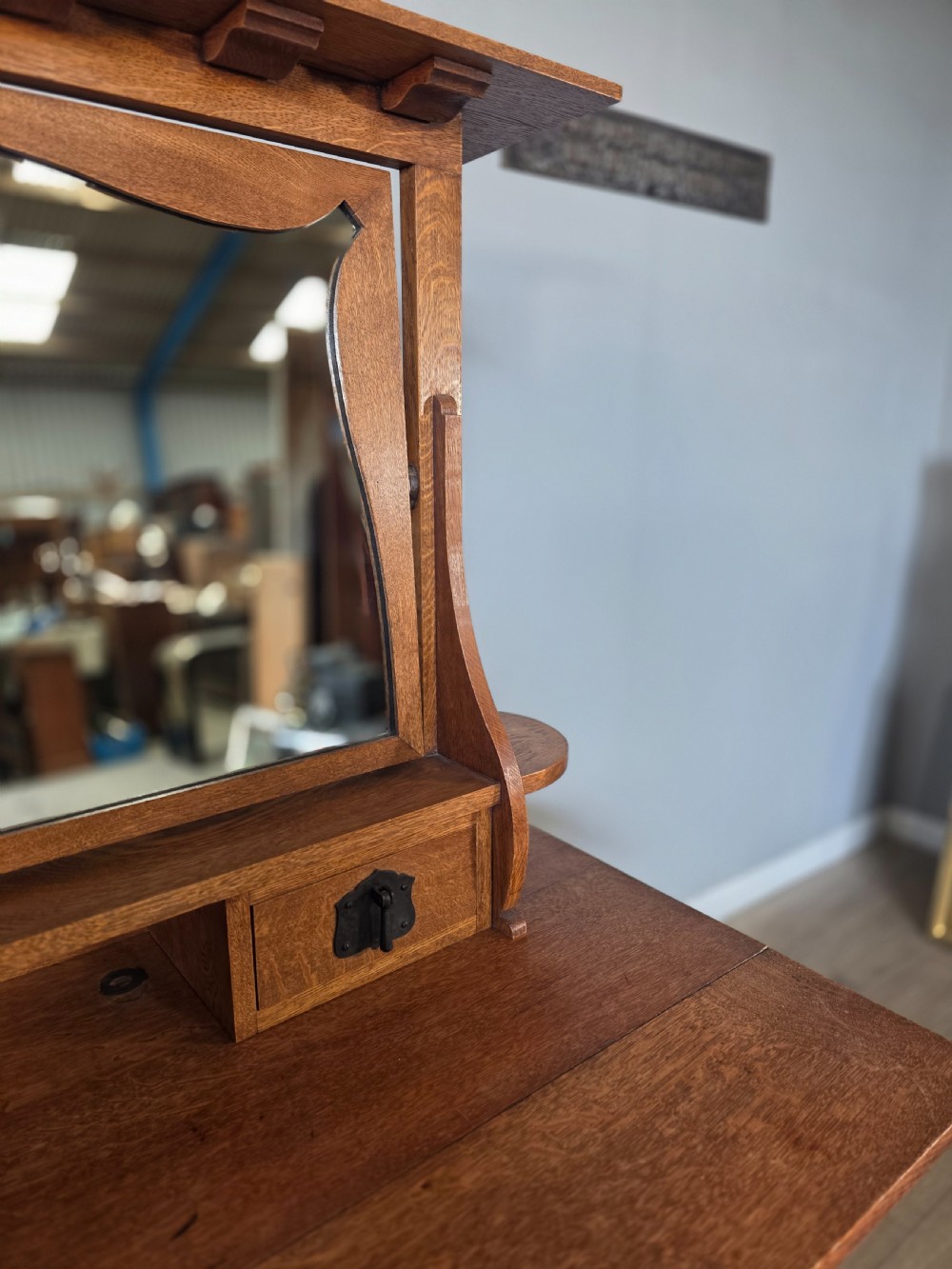 An Arts and Crafts solid oak dressing table featuring an upper mirror superstructure with side trinket drawers above a lower four-drawer chest with dark metal handles. View XI