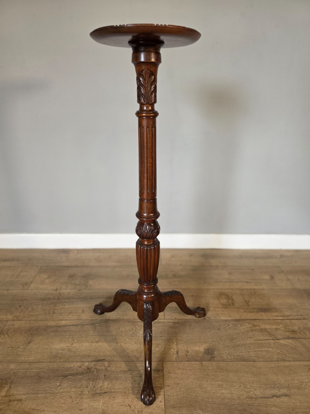 An antique dark mahogany Edwardian torchere plant stand with a circular top, fluted column, and tripod cabriole legs. View IV