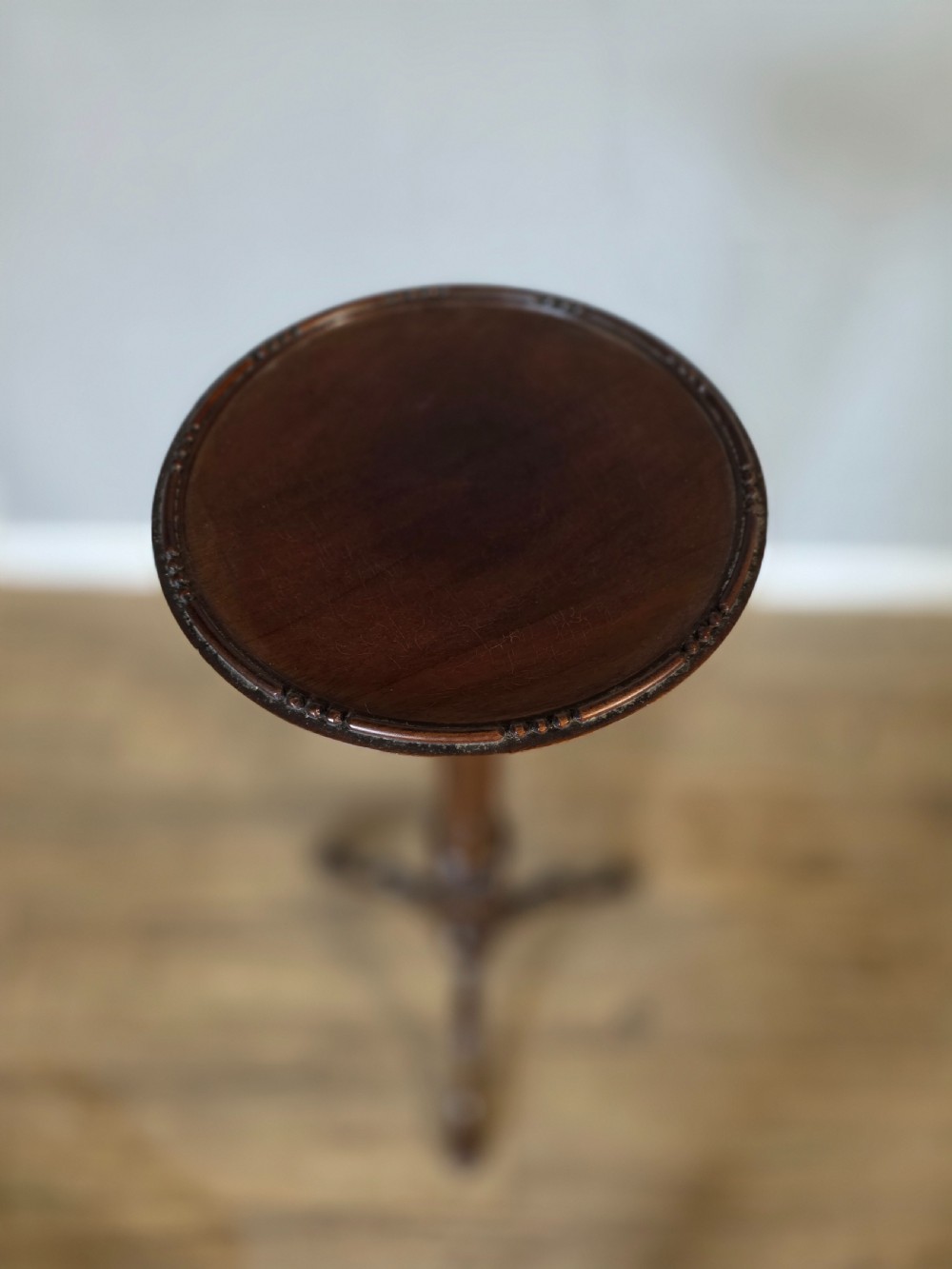 An antique dark mahogany Edwardian torchere plant stand with a circular top, fluted column, and tripod cabriole legs. View VI