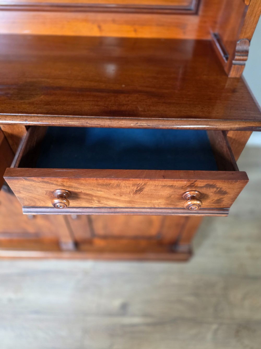 A Victorian mahogany glazed bookcase featuring a top spindle gallery, two glass cabinet doors, two drawers, and a lower double door cupboard on a plinth base. View XI
