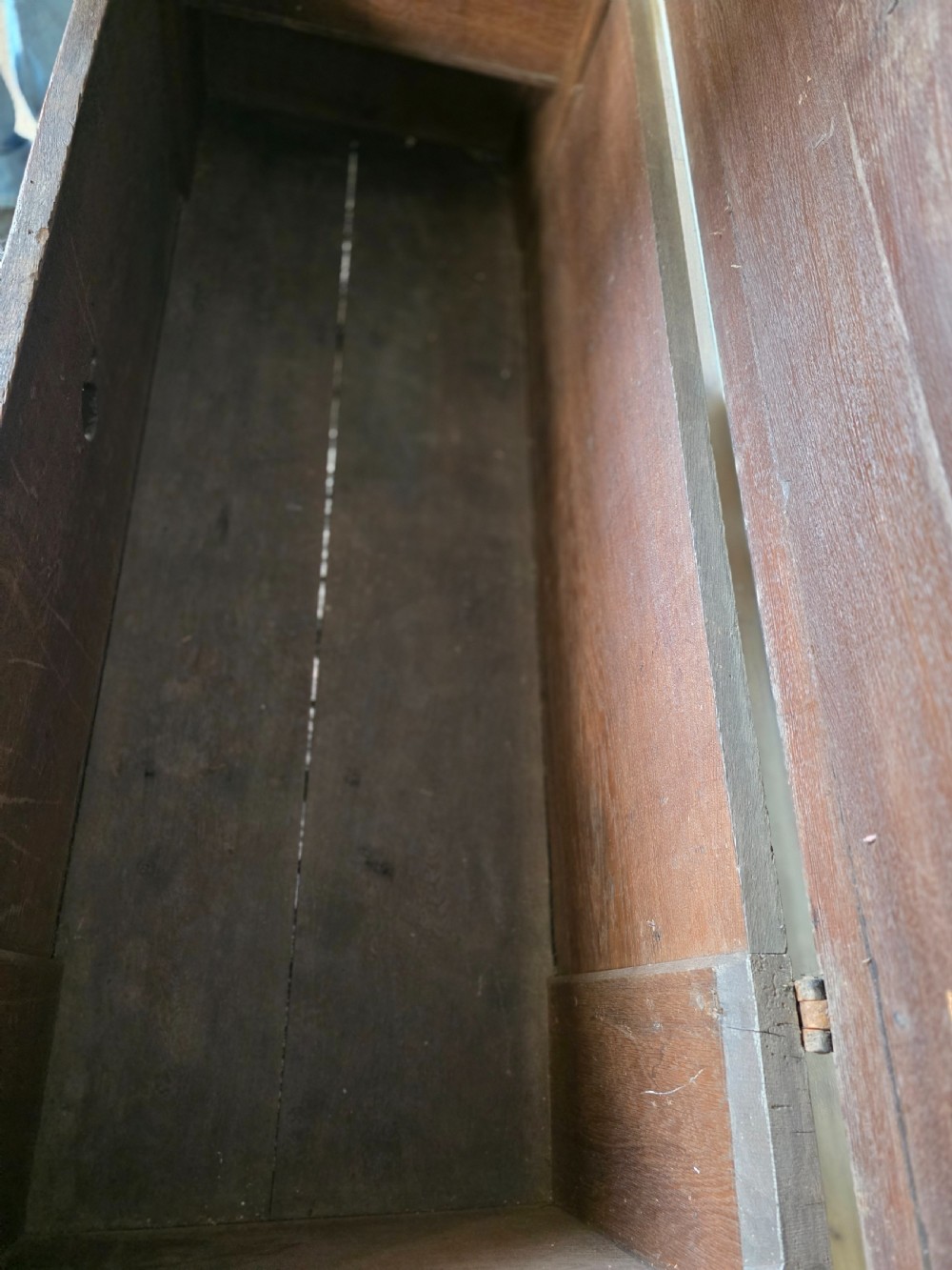 An 18th-century oak coffer featuring hand-forged wrought iron straps, a central escutcheon plate, and the carved inscription Anno 1743 on the front panel. View XIV