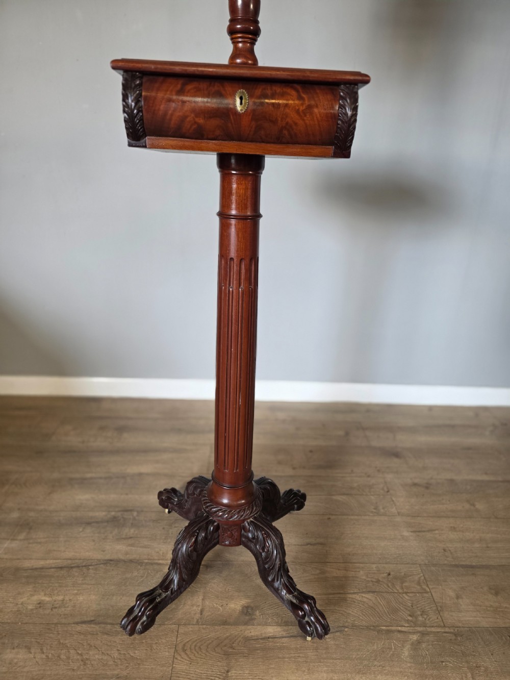 A tall mahogany gentlemans shaving stand featuring an adjustable rectangular mirror, a single drawer pedestal, a fluted column, and a carved tripod base. View IV