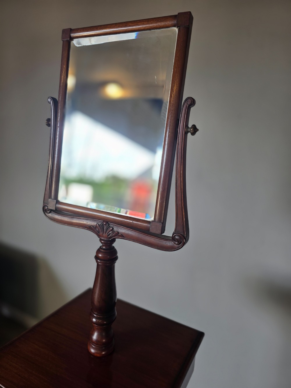 A tall mahogany gentlemans shaving stand featuring an adjustable rectangular mirror, a single drawer pedestal, a fluted column, and a carved tripod base. View VI