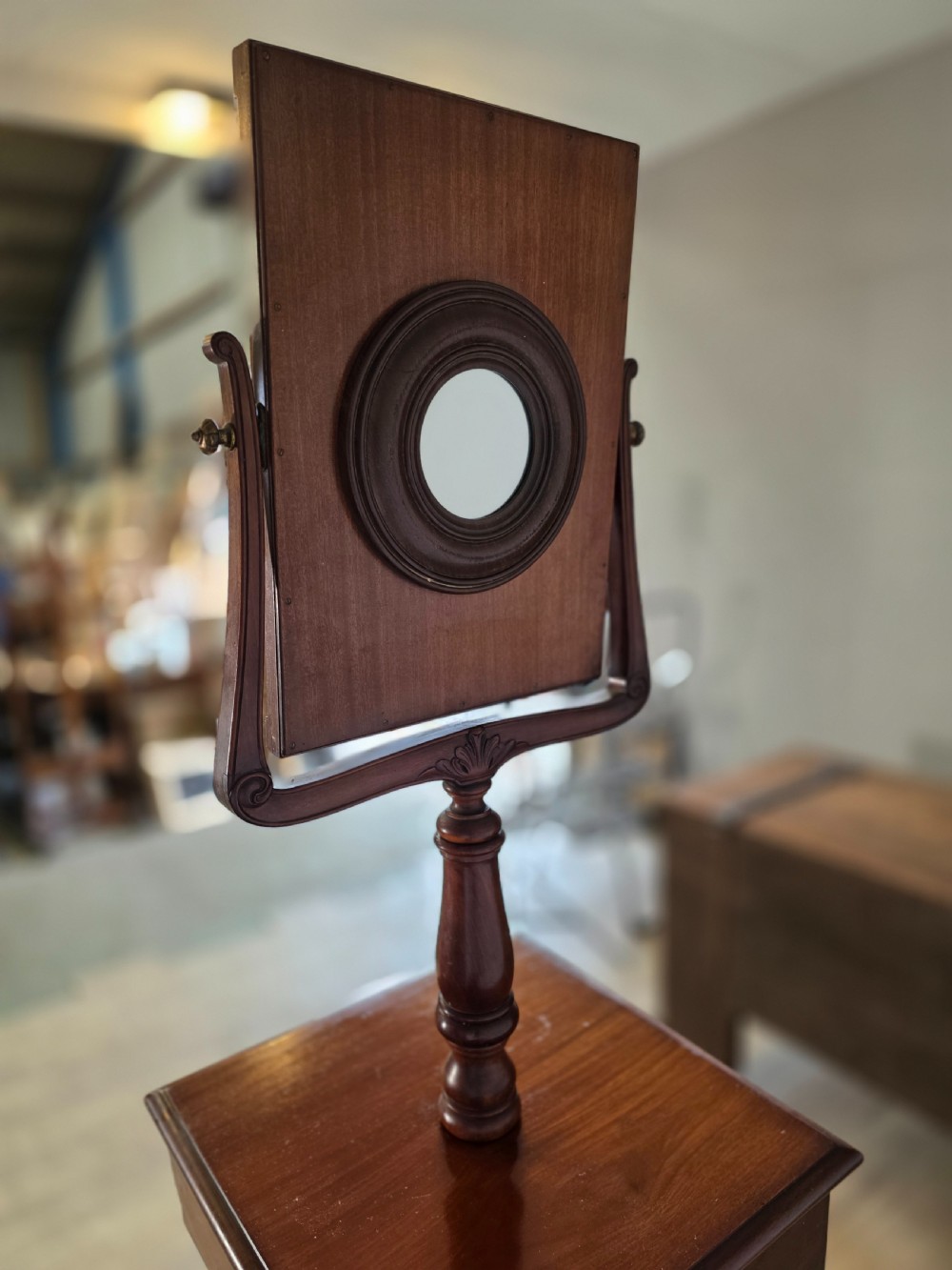 A tall mahogany gentlemans shaving stand featuring an adjustable rectangular mirror, a single drawer pedestal, a fluted column, and a carved tripod base. View VII