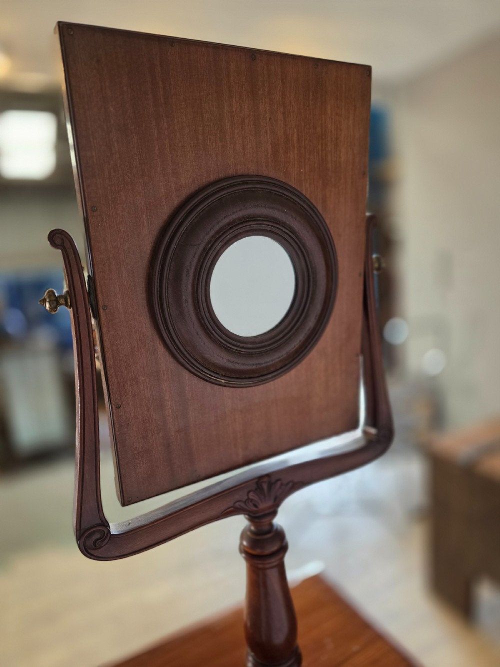 A tall mahogany gentlemans shaving stand featuring an adjustable rectangular mirror, a single drawer pedestal, a fluted column, and a carved tripod base. View VIII