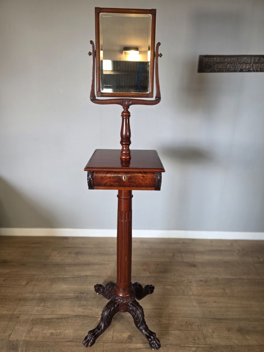 A tall mahogany gentlemans shaving stand featuring an adjustable rectangular mirror, a single drawer pedestal, a fluted column, and a carved tripod base. View XI