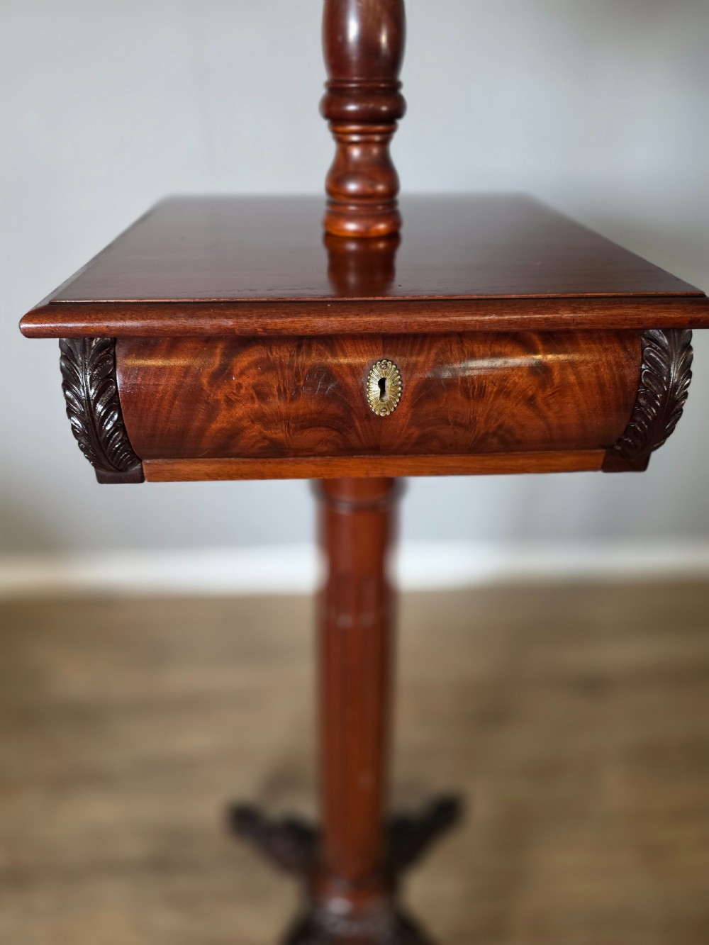 A tall mahogany gentlemans shaving stand featuring an adjustable rectangular mirror, a single drawer pedestal, a fluted column, and a carved tripod base. View XIV