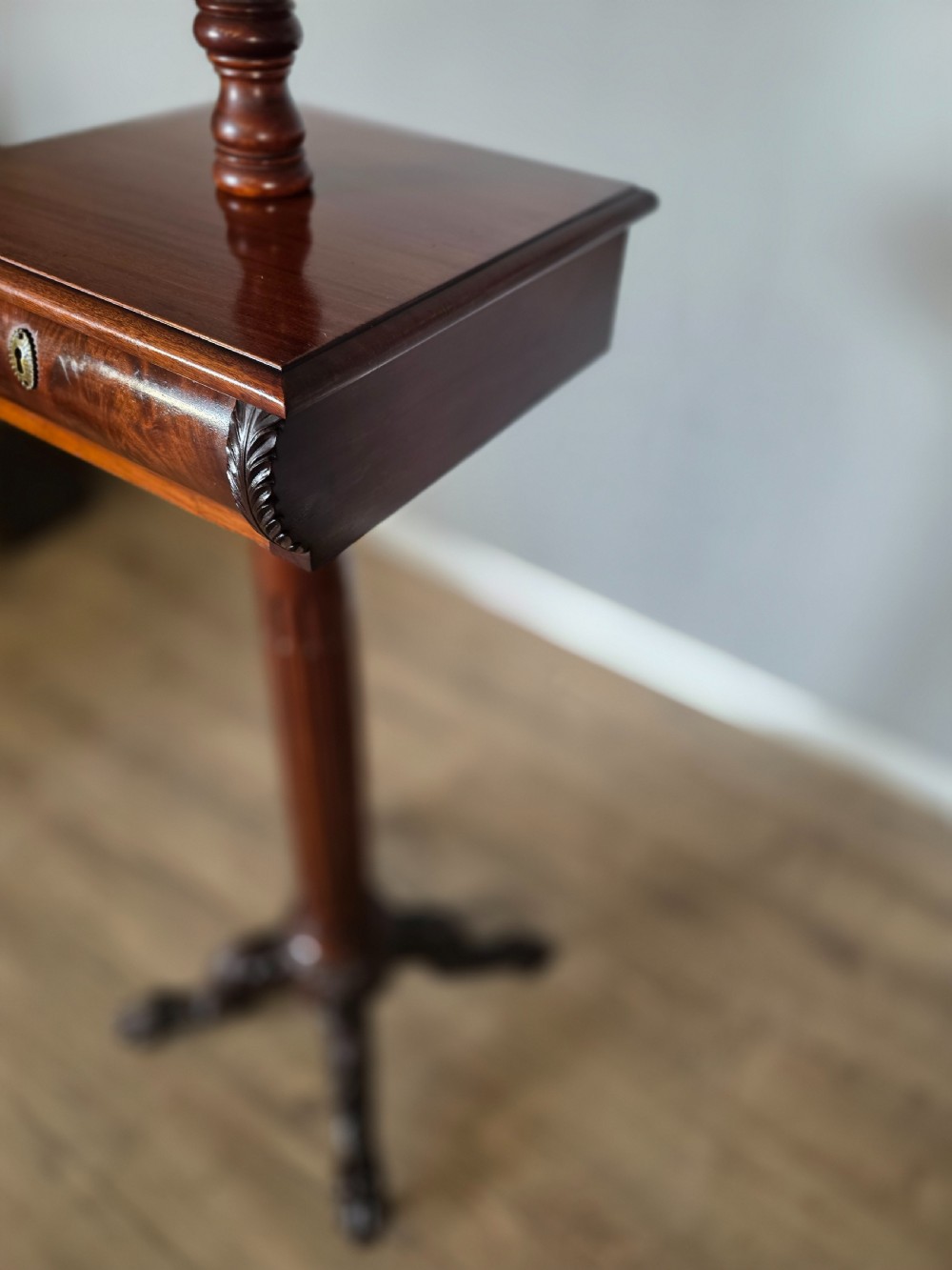 A tall mahogany gentlemans shaving stand featuring an adjustable rectangular mirror, a single drawer pedestal, a fluted column, and a carved tripod base. View XV