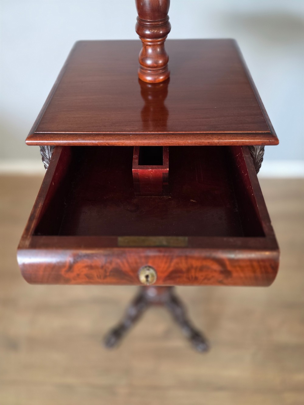 A tall mahogany gentlemans shaving stand featuring an adjustable rectangular mirror, a single drawer pedestal, a fluted column, and a carved tripod base. View XIX