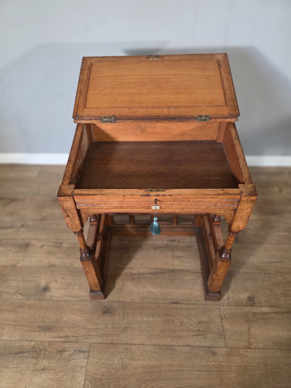 A late Victorian oak clerks desk with an inset green leather writing top, turned legs, and an arcaded lower framework. View V