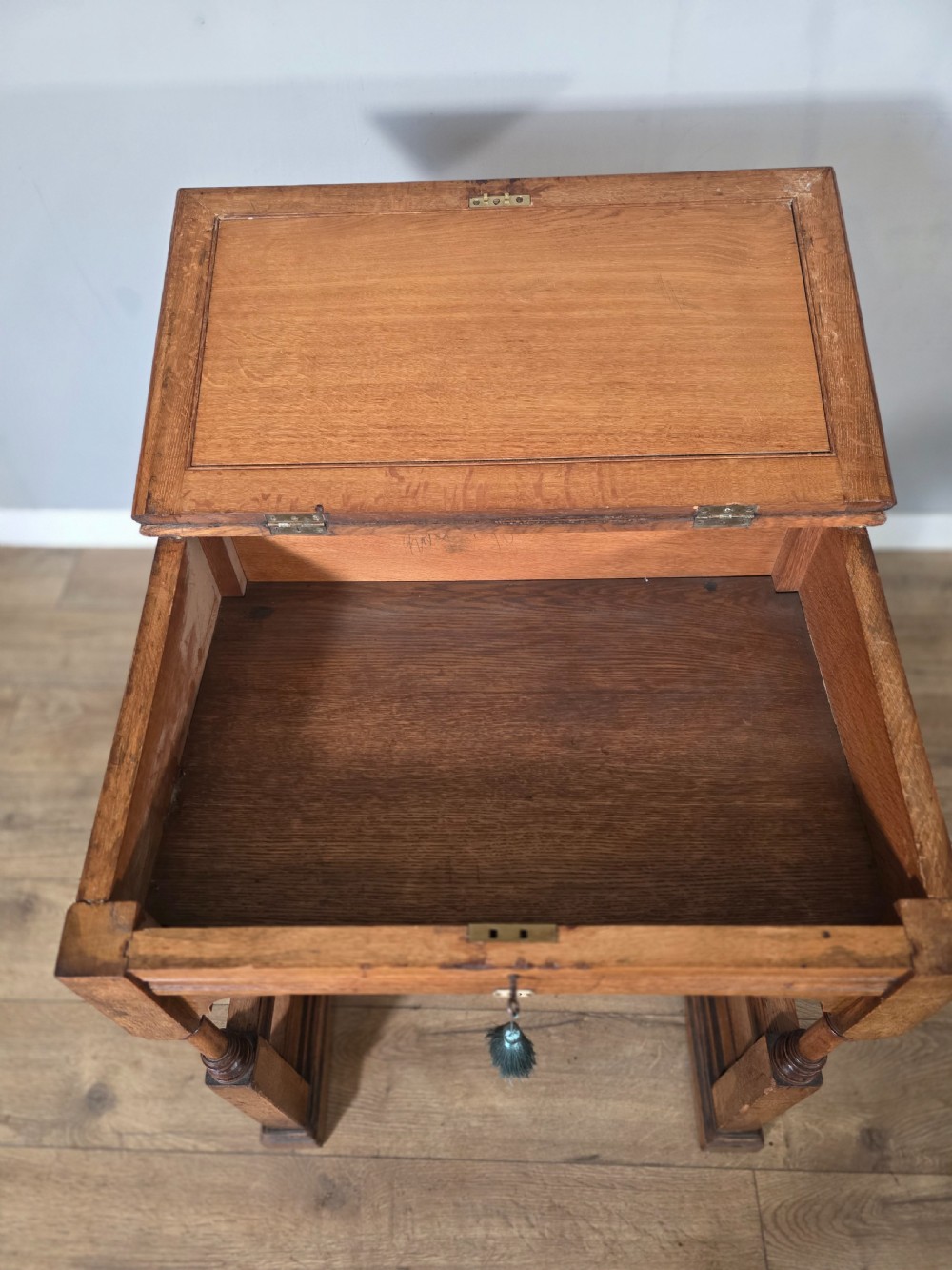 A late Victorian oak clerks desk with an inset green leather writing top, turned legs, and an arcaded lower framework. View VI