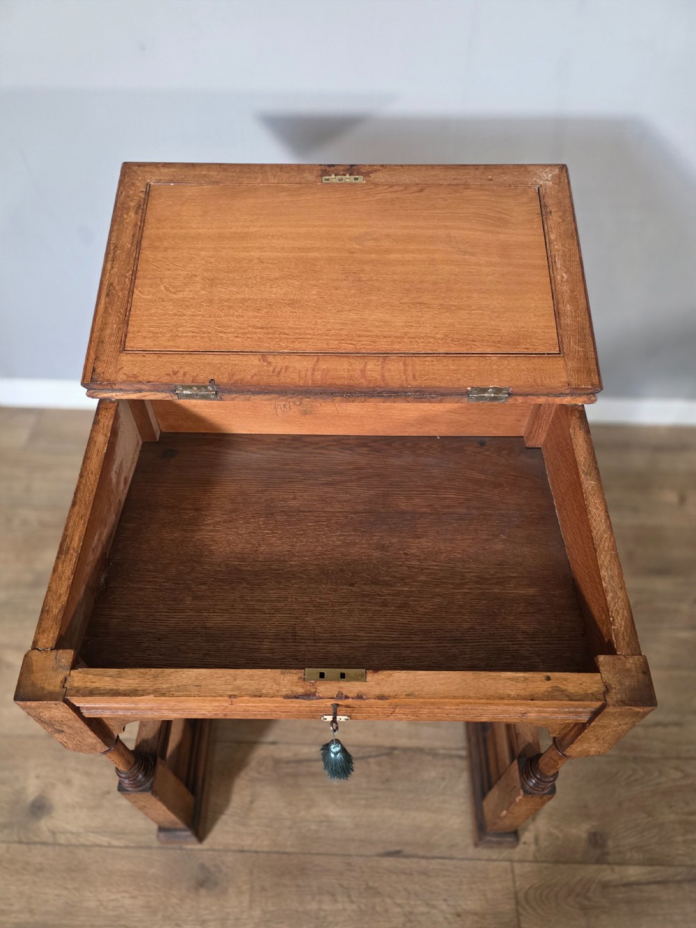 A late Victorian oak clerks desk with an inset green leather writing top, turned legs, and an arcaded lower framework. View VII