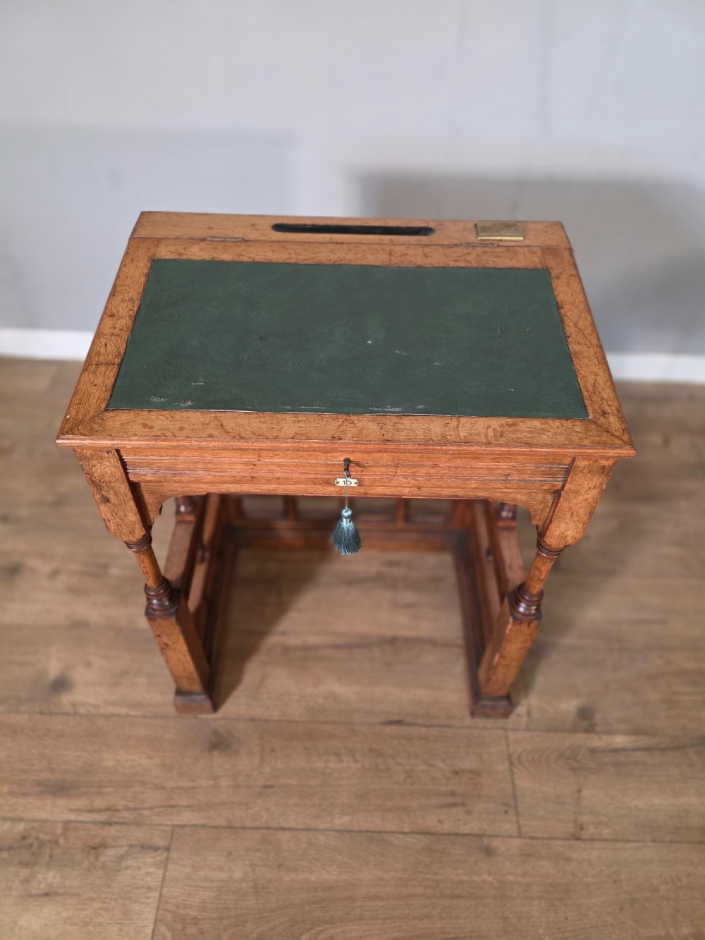 A late Victorian oak clerks desk with an inset green leather writing top, turned legs, and an arcaded lower framework. View VIII
