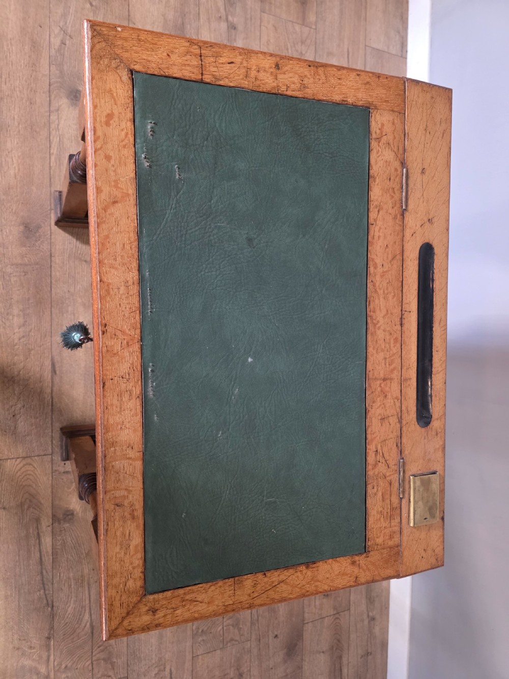 A late Victorian oak clerks desk with an inset green leather writing top, turned legs, and an arcaded lower framework. View XI