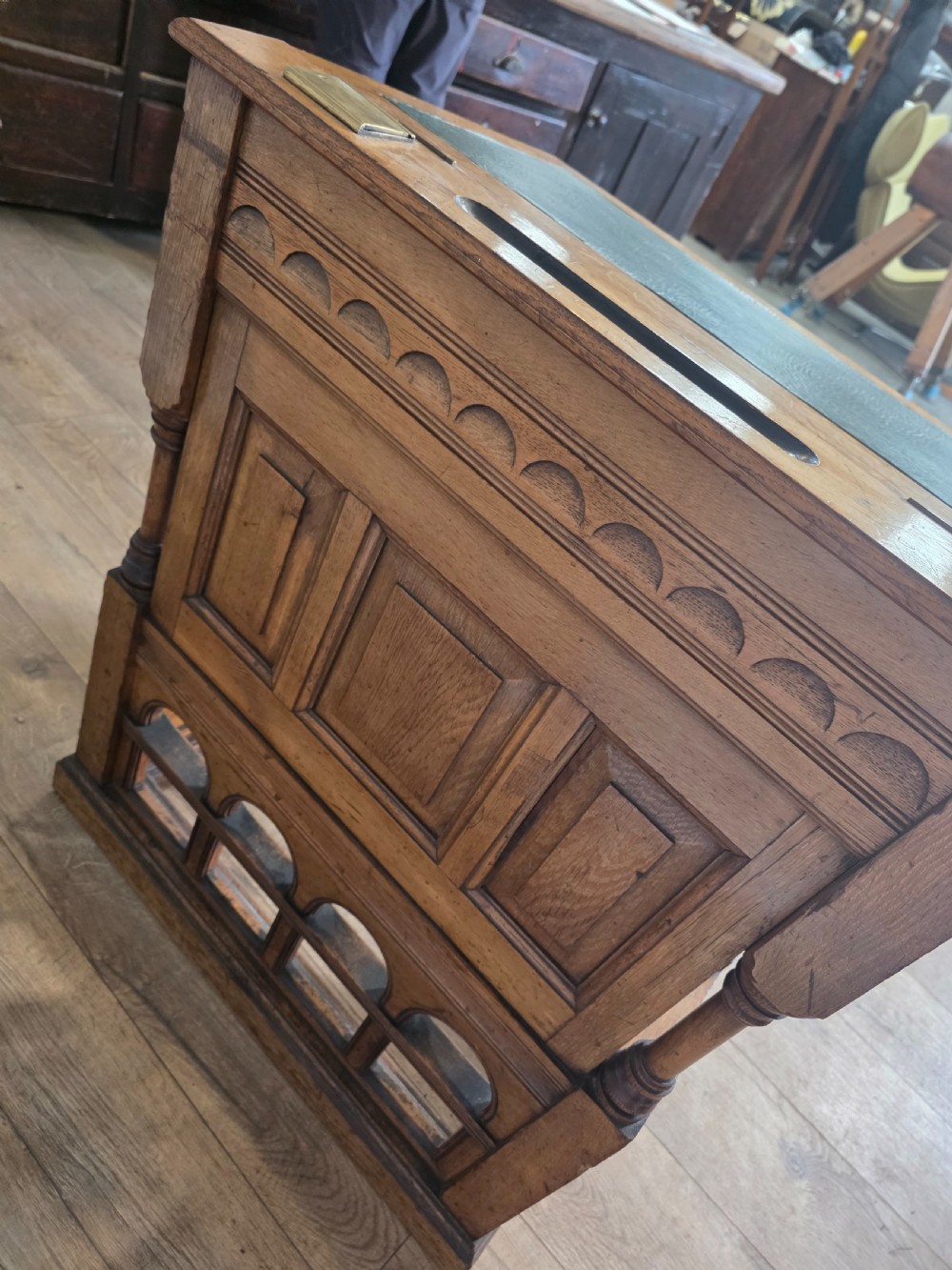 A late Victorian oak clerks desk with an inset green leather writing top, turned legs, and an arcaded lower framework. View XIII